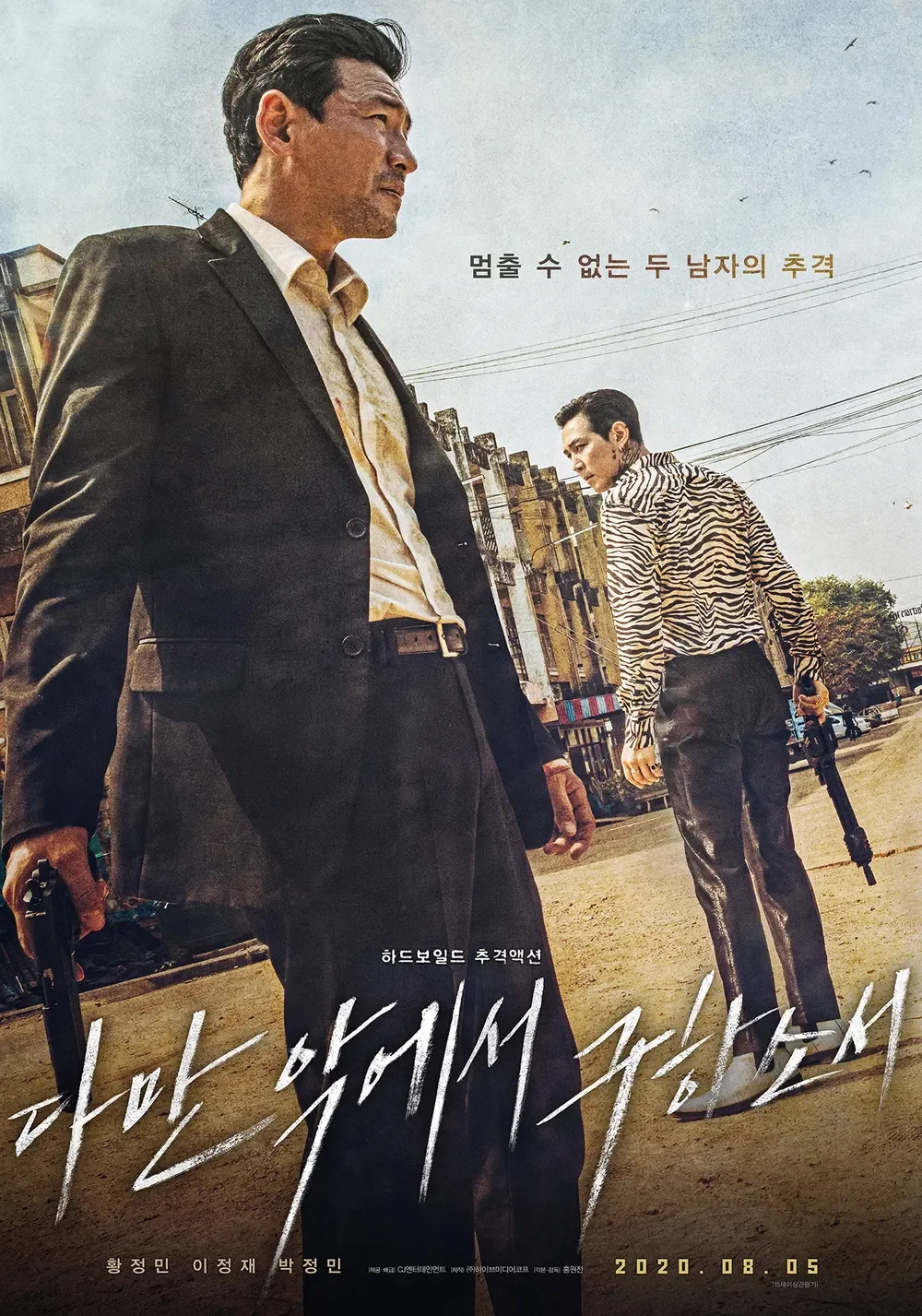 Movie poster featuring two men holding guns in an urban street scene with power lines and buildings. One man in a suit faces the camera while the other, with a zebra-print jacket, has his back turned. Korean text and a release date are also visible.