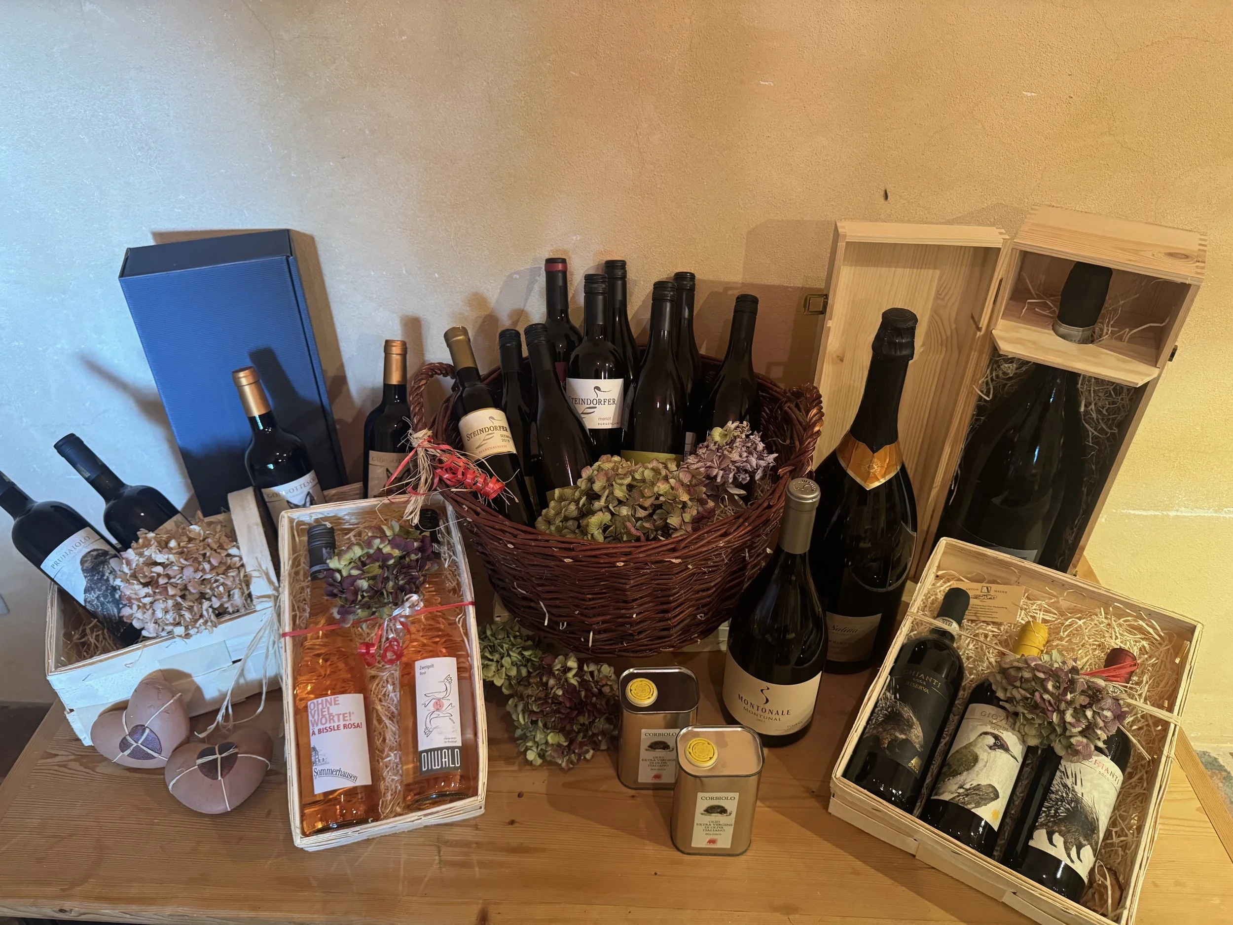 Flasche Wein, Weinregale, Holzboxen mit Wein, dekorative Flasche und Geschenkartikel auf einem Holztisch.
