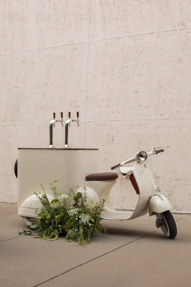 A vintage Vespa with a custom tap system—the most photographed thing at any event it's been to. Serves cold brew, sparkling drinks, zero-proof cocktails, and more. Fits indoor and outdoor spaces. Arrives dressed with florals.