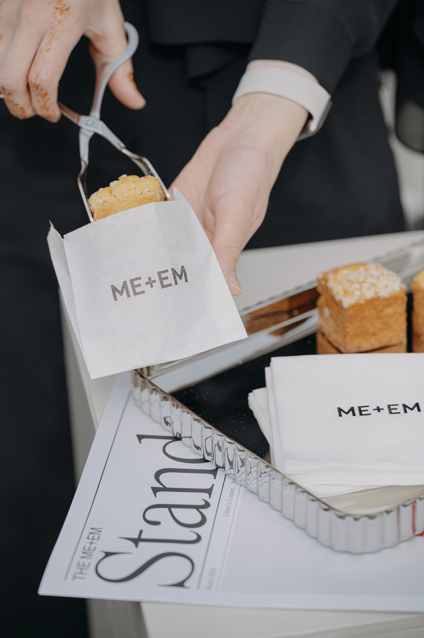 ME+EM branded pastry bags and napkins displayed on a styled event table during a Siya Studio brand activation at the ME+EM California store opening