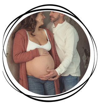 Ein schwangeren Paar hält die Hände auf ihrem Babybauch.