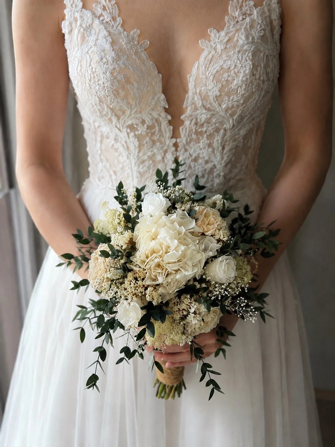 Bouquet de mariée bohème chic en fleurs séchées et stabilisées, composé de pivoines blanches, roses stabilisées, statice blanc, mousse végétale et feuillage d’eucalyptus noir. Cette création artisanale associe élégance, douceur et caractère pour un m