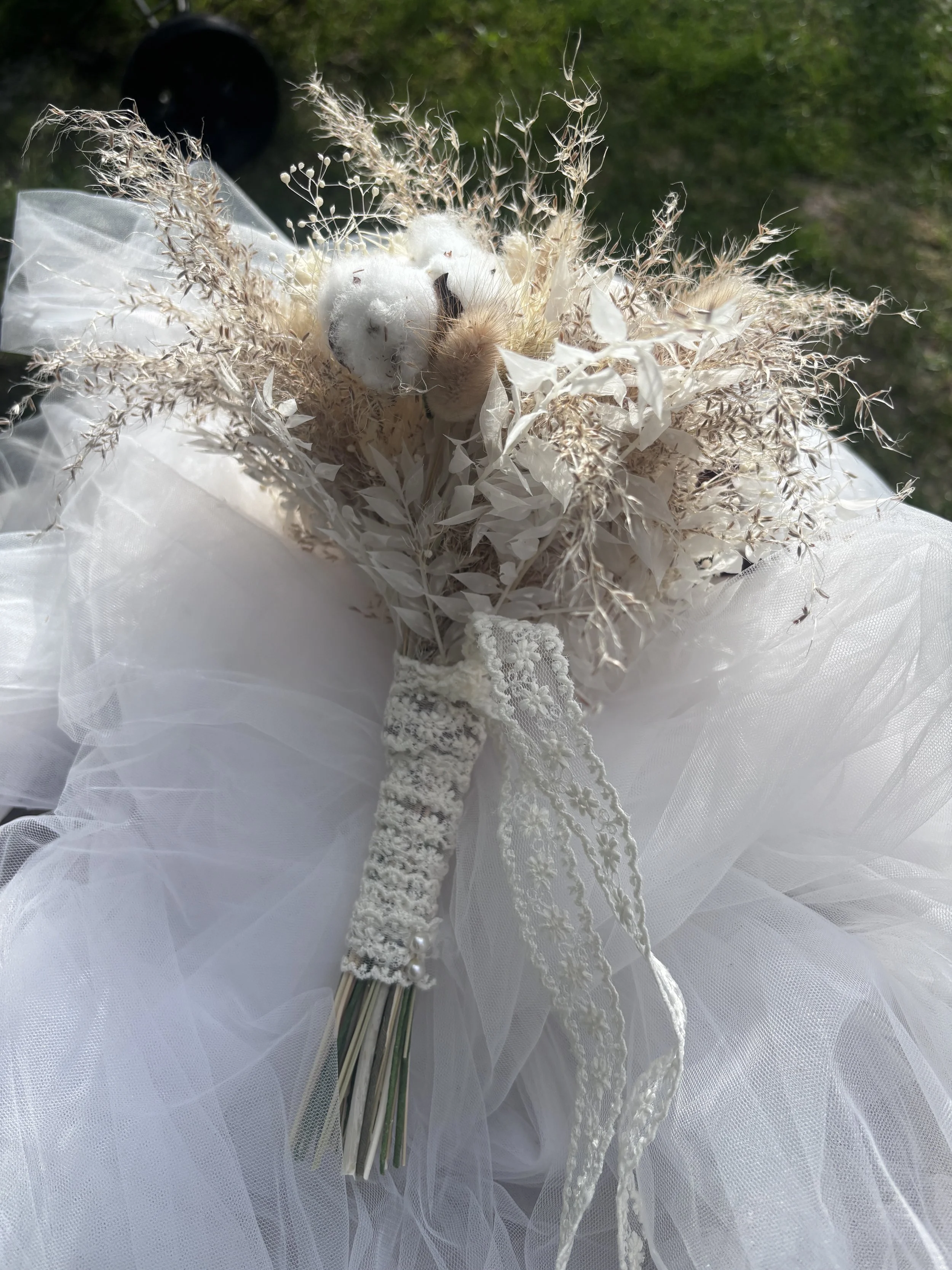 Bouquet de mariée bohème composé de fleurs séchées et stabilisées dans des tons blanc cassé, ivoire et beige naturel. Réalisé à la main par L’Atelier Fleurs & Sens à Saint-Saulve, près de Valenciennes, ce bouquet associe roses stabilisées, coton, gra