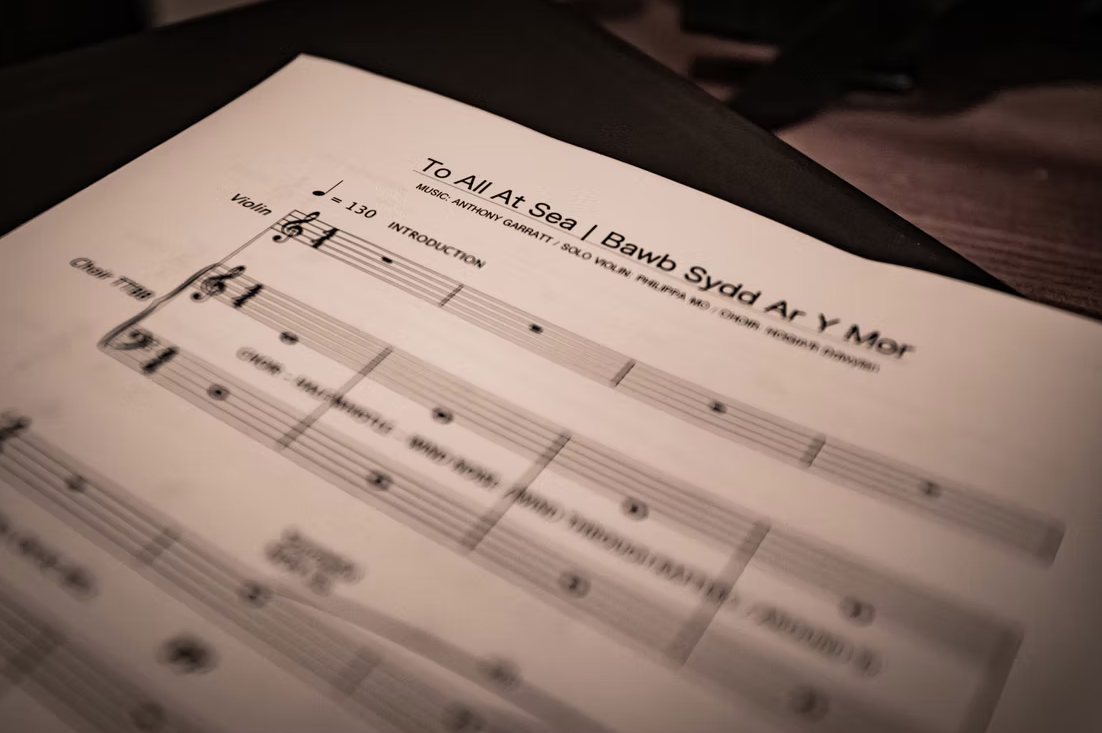 Music sheet titled 'To All At Sea' by Anthony Garratt, featuring musical notation for violin and other instruments, with a tempo marking of 130 beats per minute.