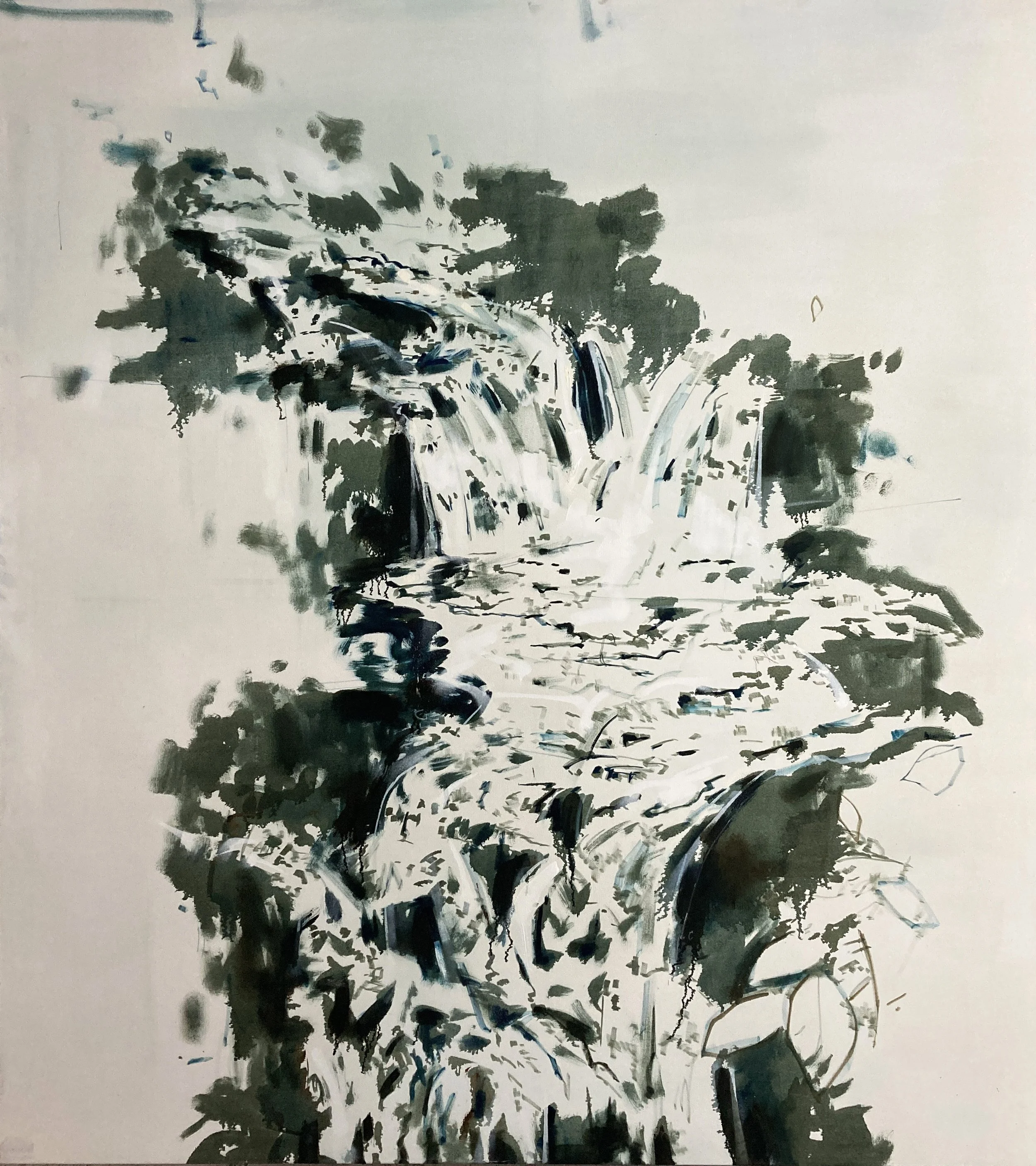 Waterfall flowing over rocks and surrounded by lush green trees.