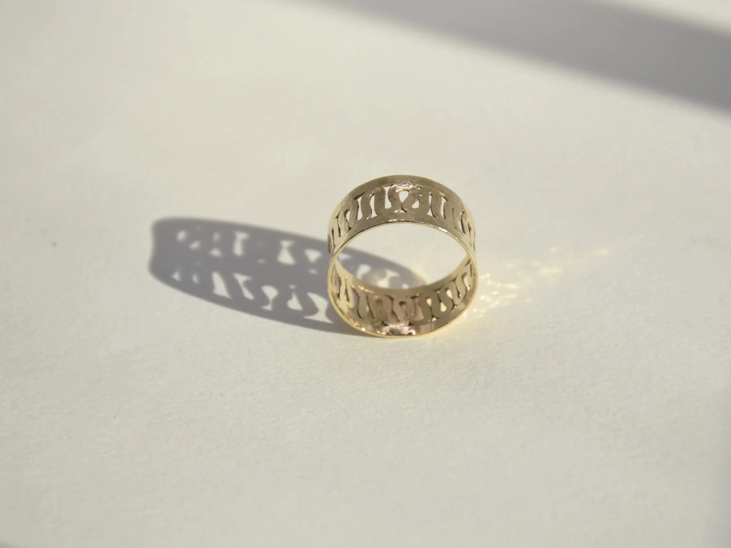Bague Villa romaine  en or où l'ombre du soleil projette une colonnade sur un fond clair
