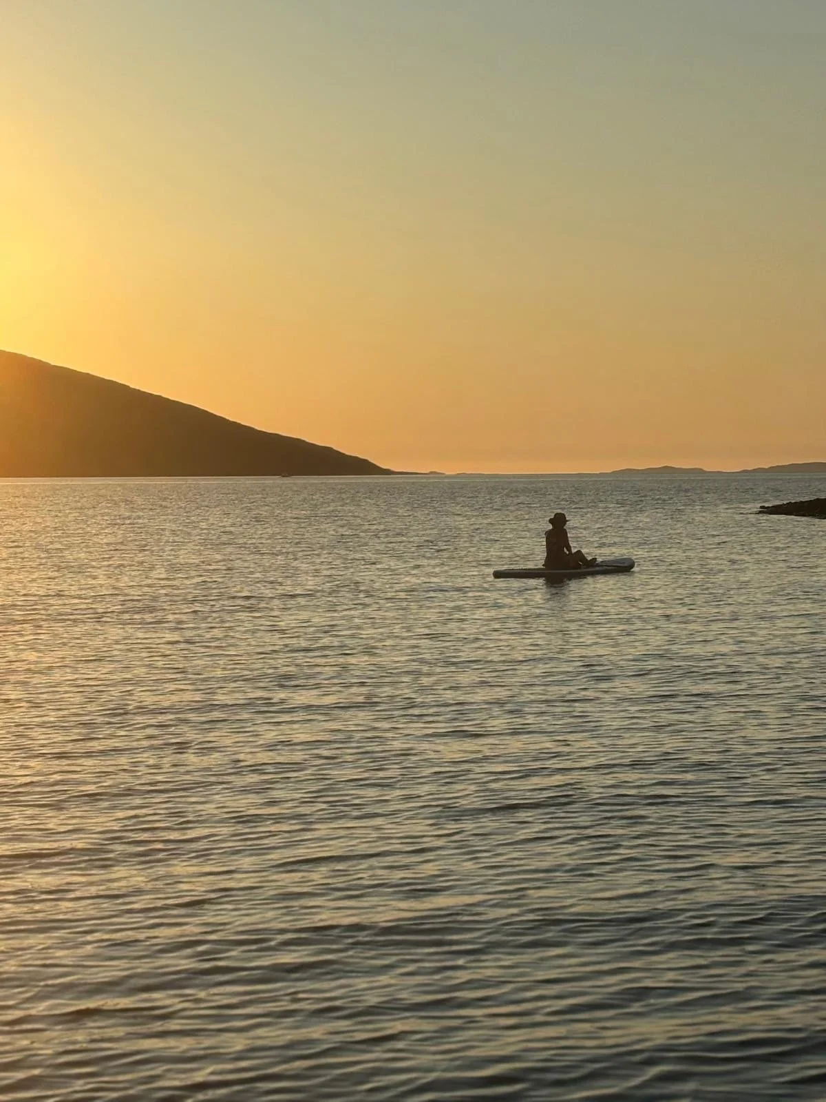 Paddleboarding on calm seas representing Wellbeing Coaching helping to overcome challenges and move forward