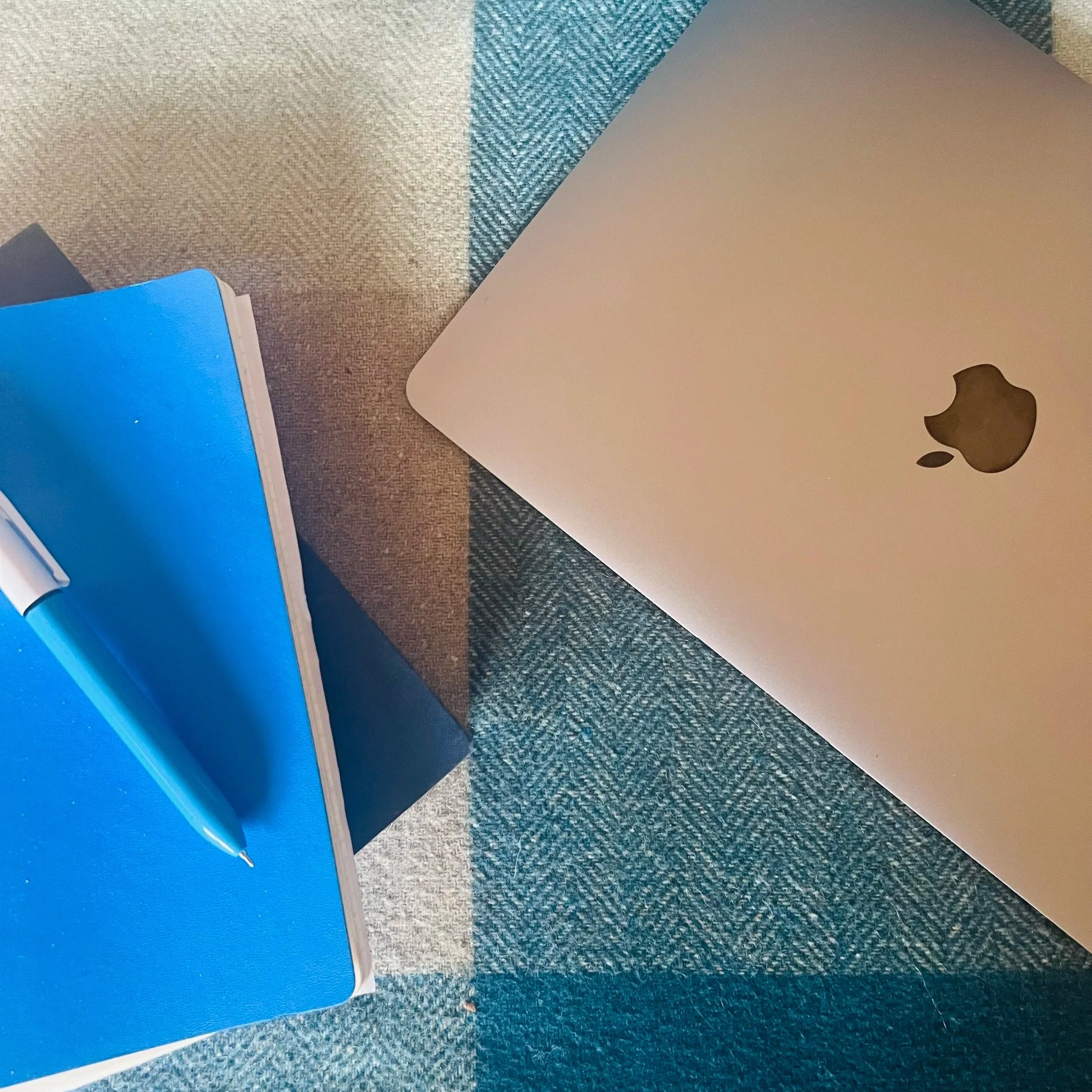 Notebook and Pen, Laptop, representing content and copywriting services