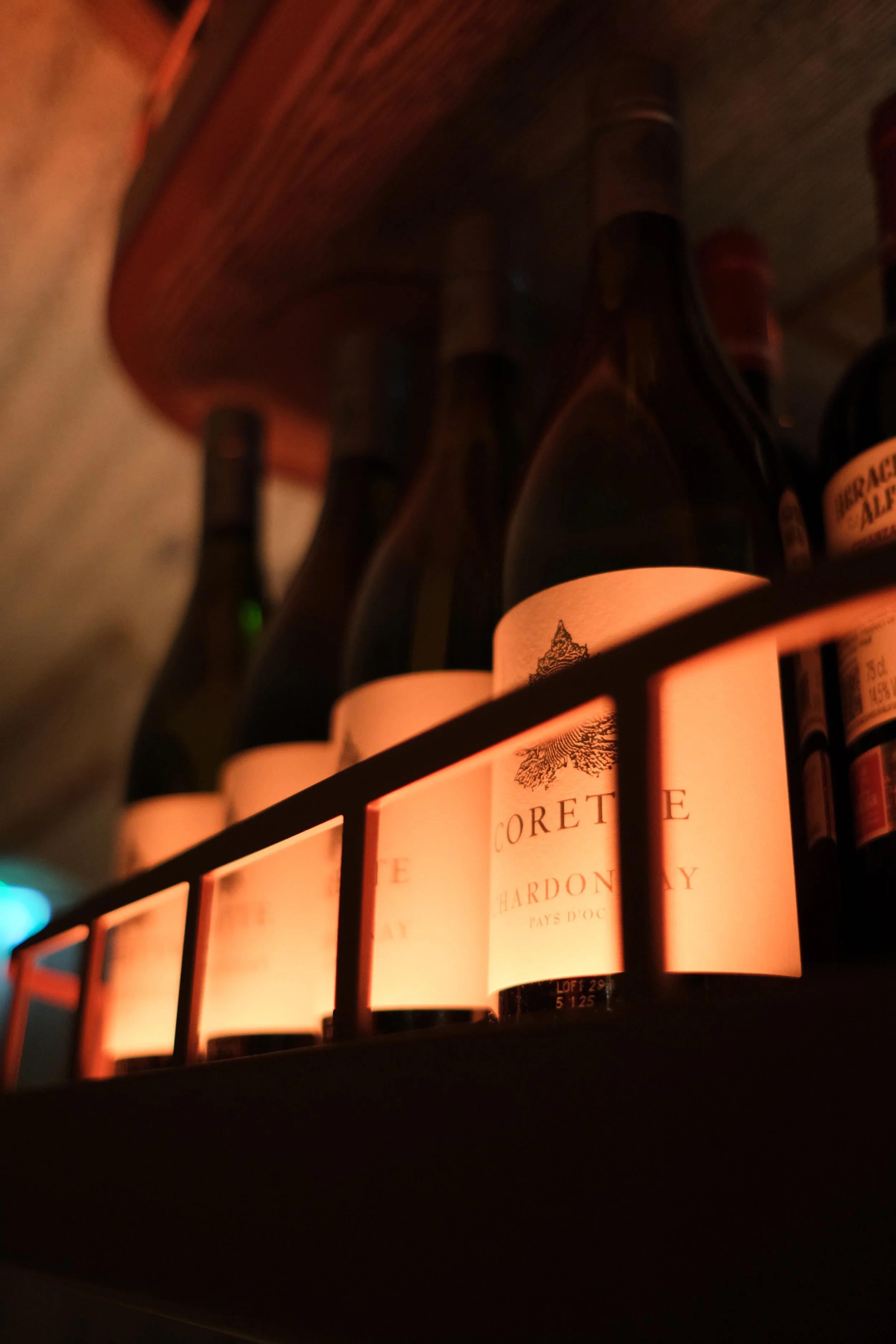 Wijnflessen in een wijnkast met warme vervaagde verlichting.