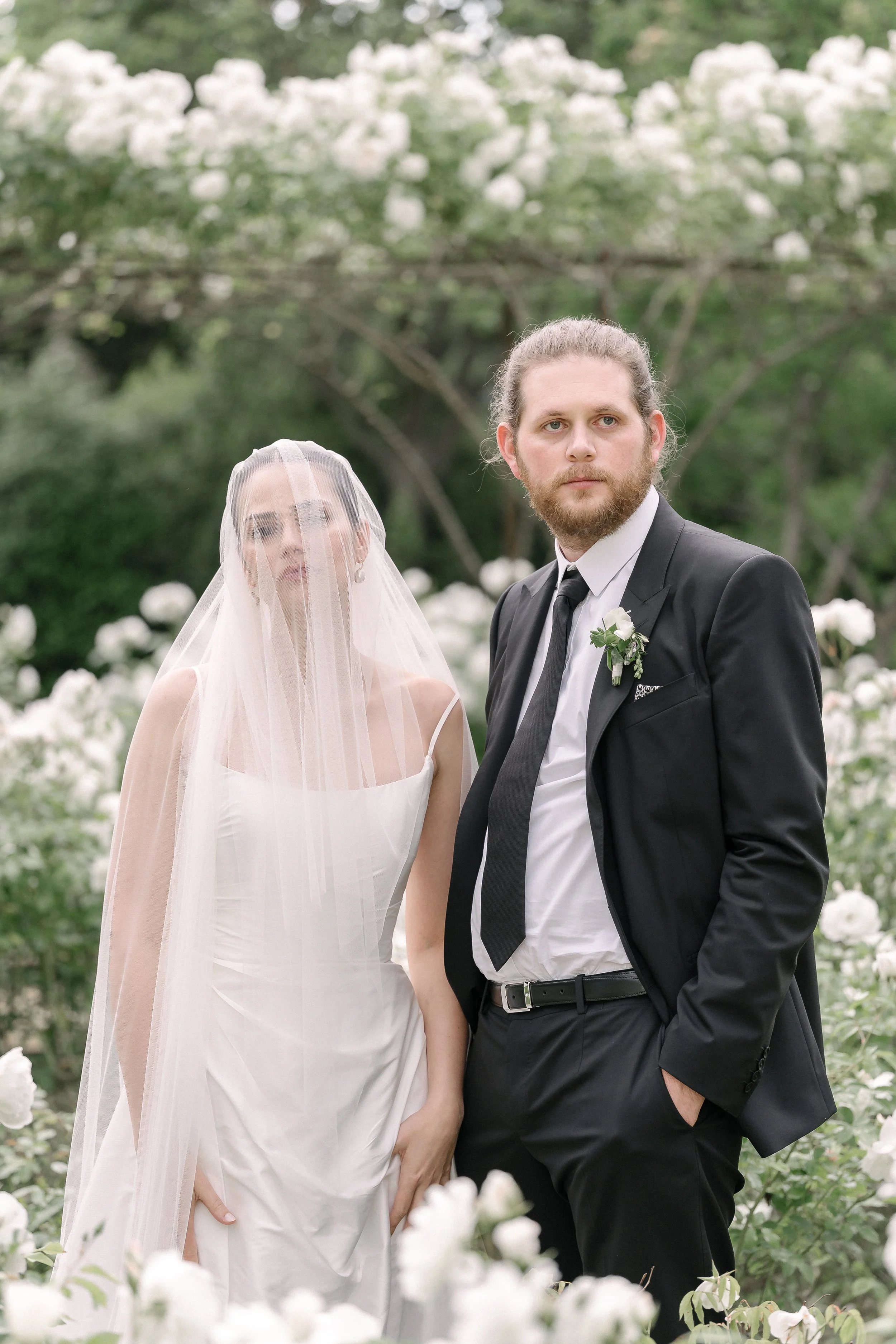 Couple de mariés posant dans un jardin fleuri, séance photo de mariage en Provence