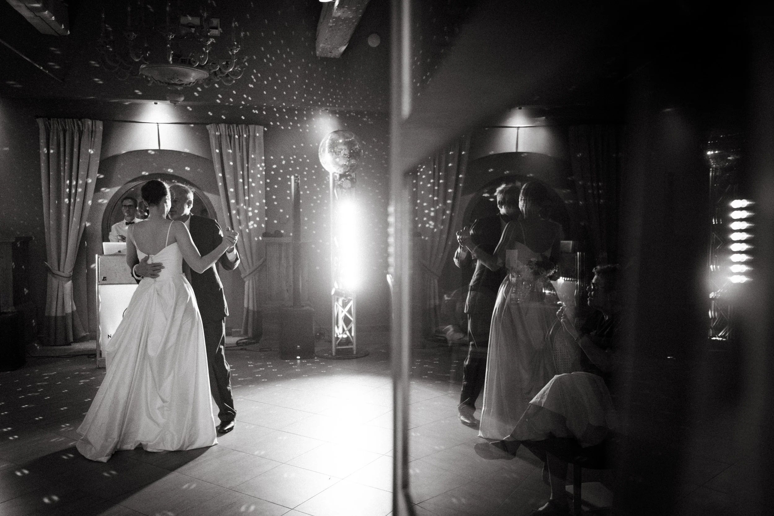 Une scène de danse lors d'un mariage, les mariés dans alors que leurs reflet double la scène.