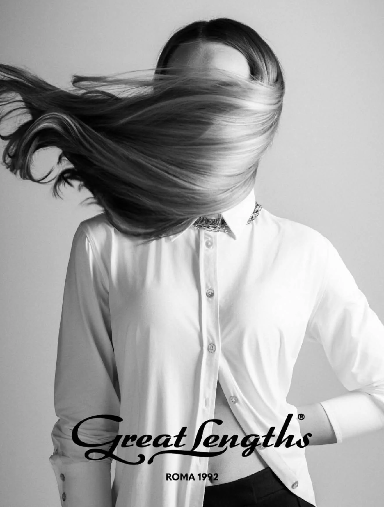 Une personne portant une chemise blanche dont le visage est dissimulé par de longs cheveux allant d'un côté à l'autre de la tête, avec le texte 'Great Lengths' et 'ROMA 1992' en bas.