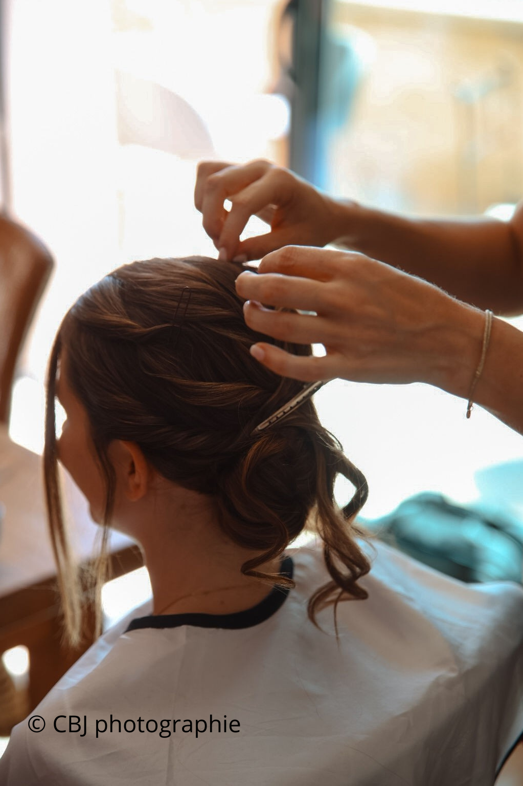 mariée se faisant coiffer par des mains délicates