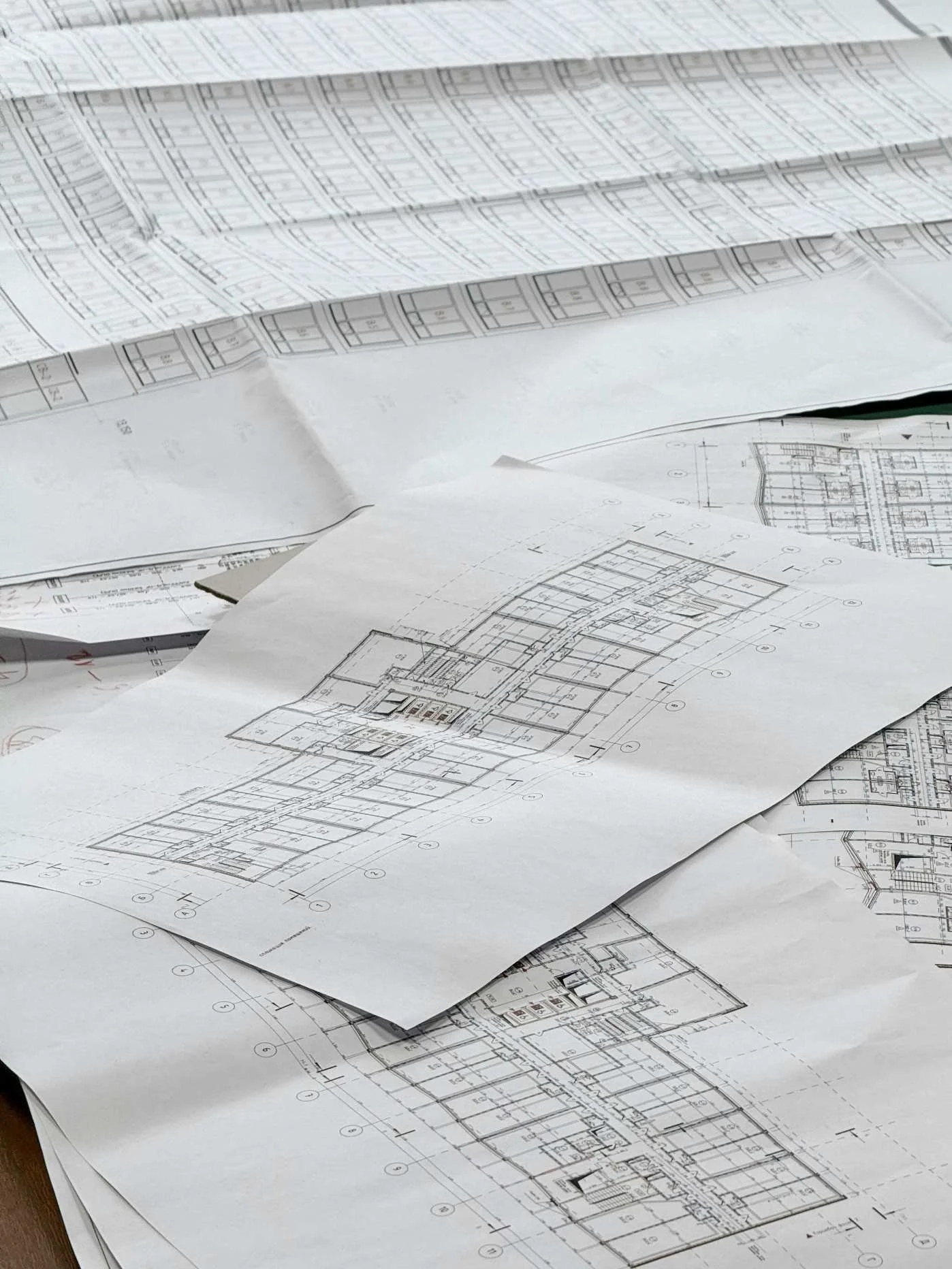 Dessins d'architecte ou plans de construction en papier dispersés sur une surface.
