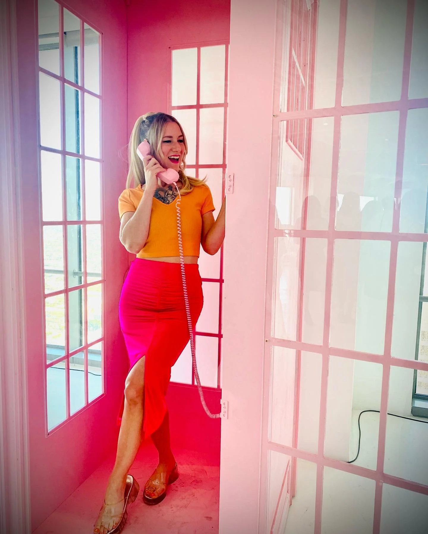 subject stands in phone booth talking on the phone