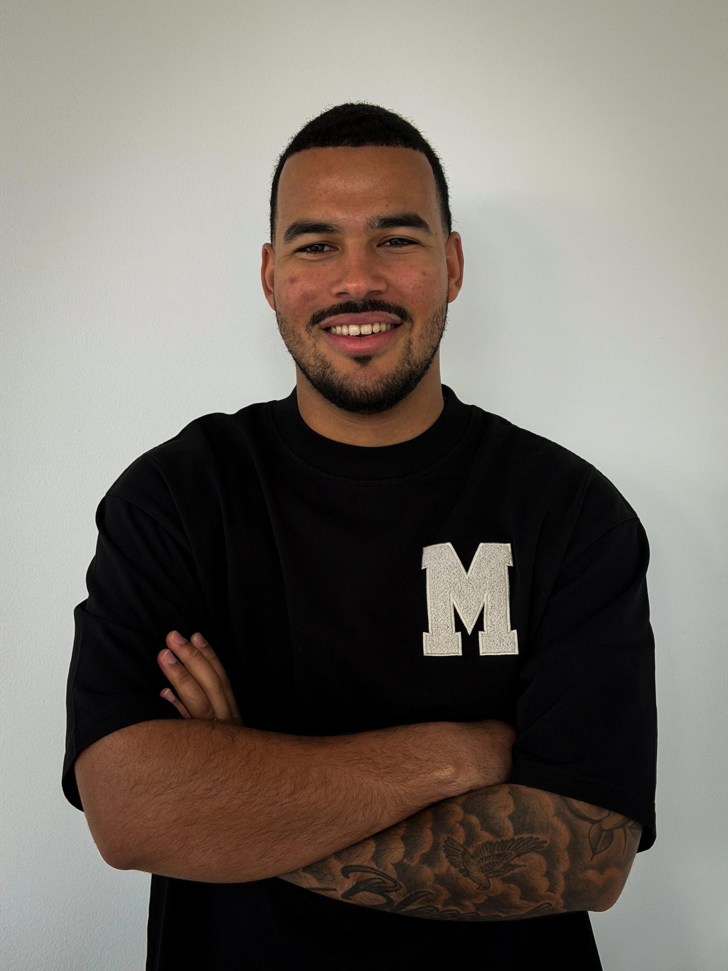 A line drawing of a modern house with multiple levels and angular design, featuring a shingled roof, various windows, and a gated entrance.