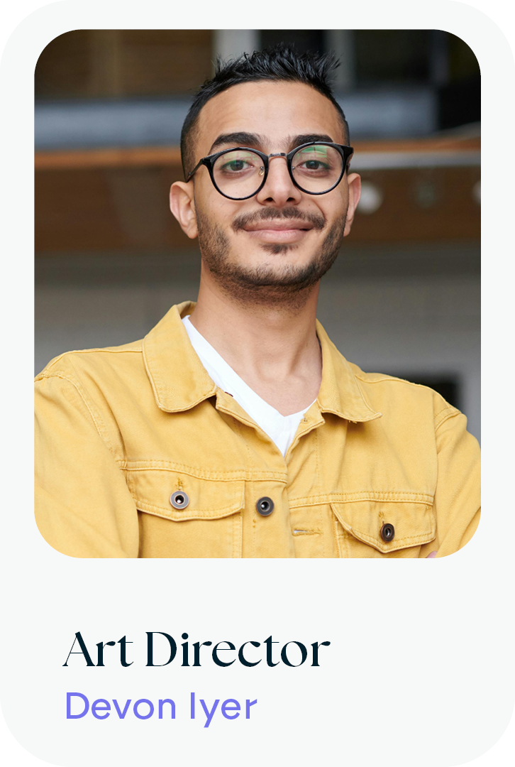 A young man with glasses, dark hair, and a slight beard, smiling and posing for a photo, wearing a yellow jacket.
