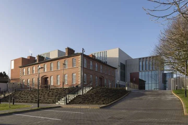 Exterior of the completed Wexford Courthouse PPP project, an old brick building and a modern glass building on a sunny day with a clear blue sky in the background.