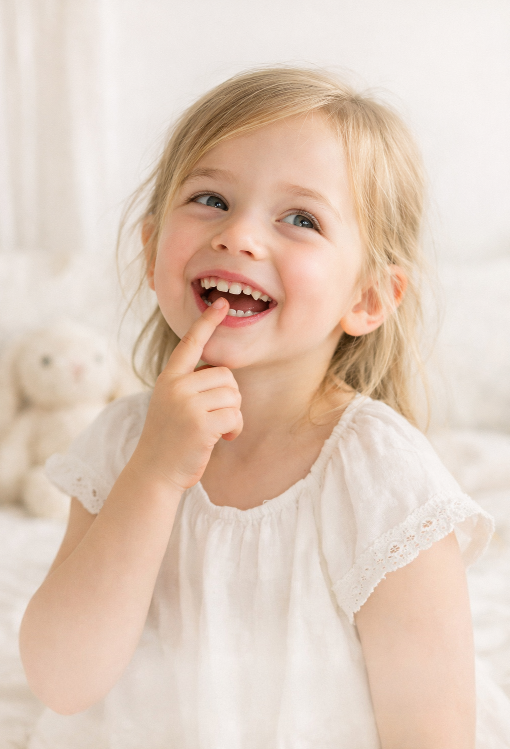 Little child with a wiggly tooth beside The Tooth Fairy Treasury keepsake kit with wooden box and Tooth Fairy notes