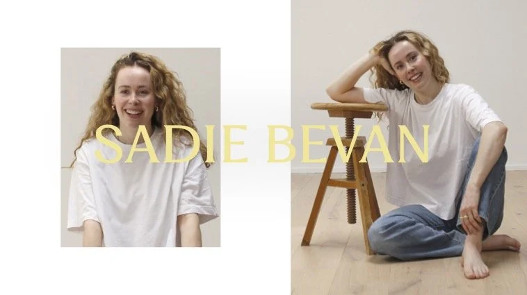 A split image of a young woman with curly blonde hair, smiling. The left side shows her in a white shirt with the name "Sadie Bevan" in yellow text. The right side shows her sitting on the floor with one arm resting on a wooden stool, wearing the same white shirt and blue jeans, relaxed and smiling.
