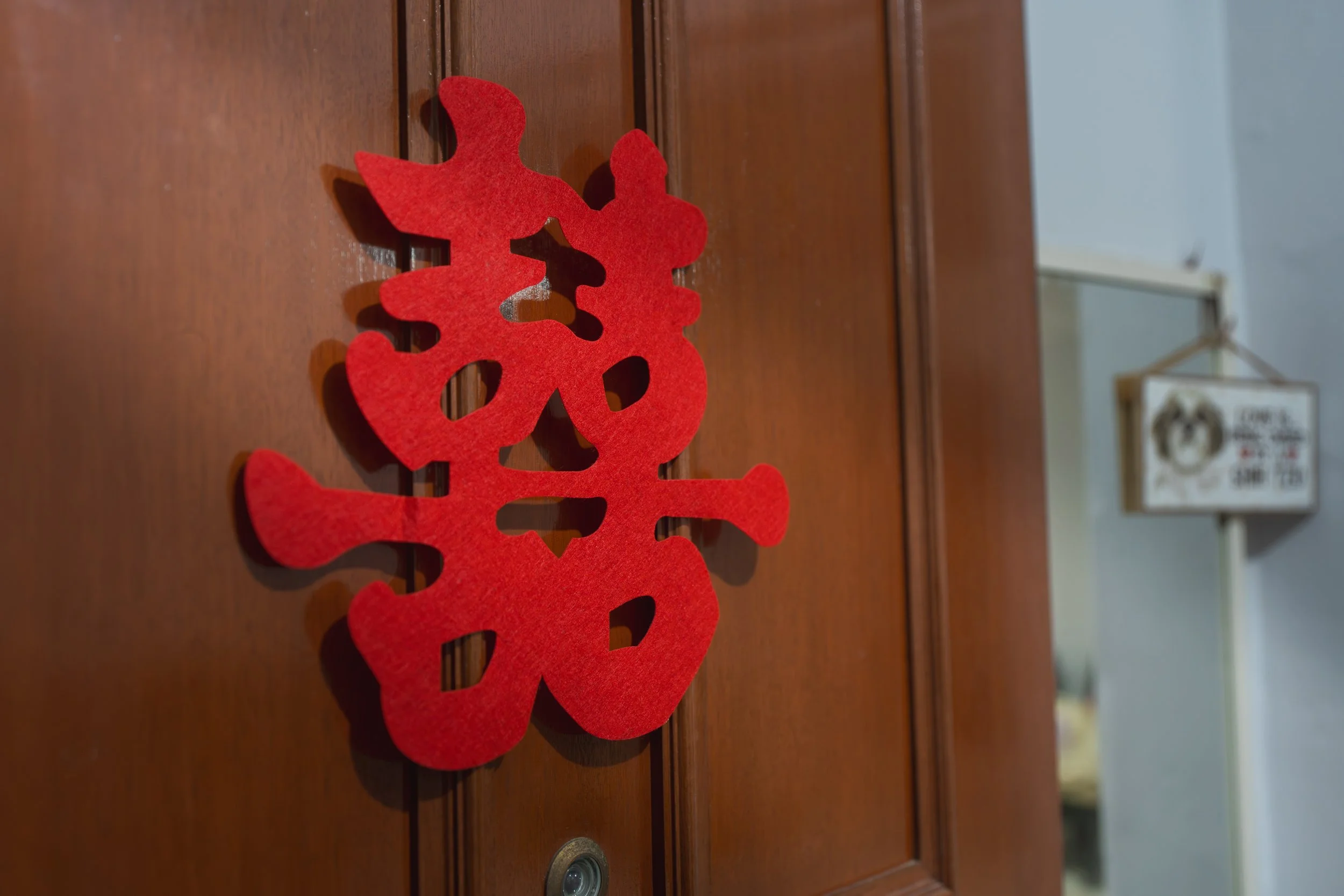 Red Chinese character decoration on wooden door.