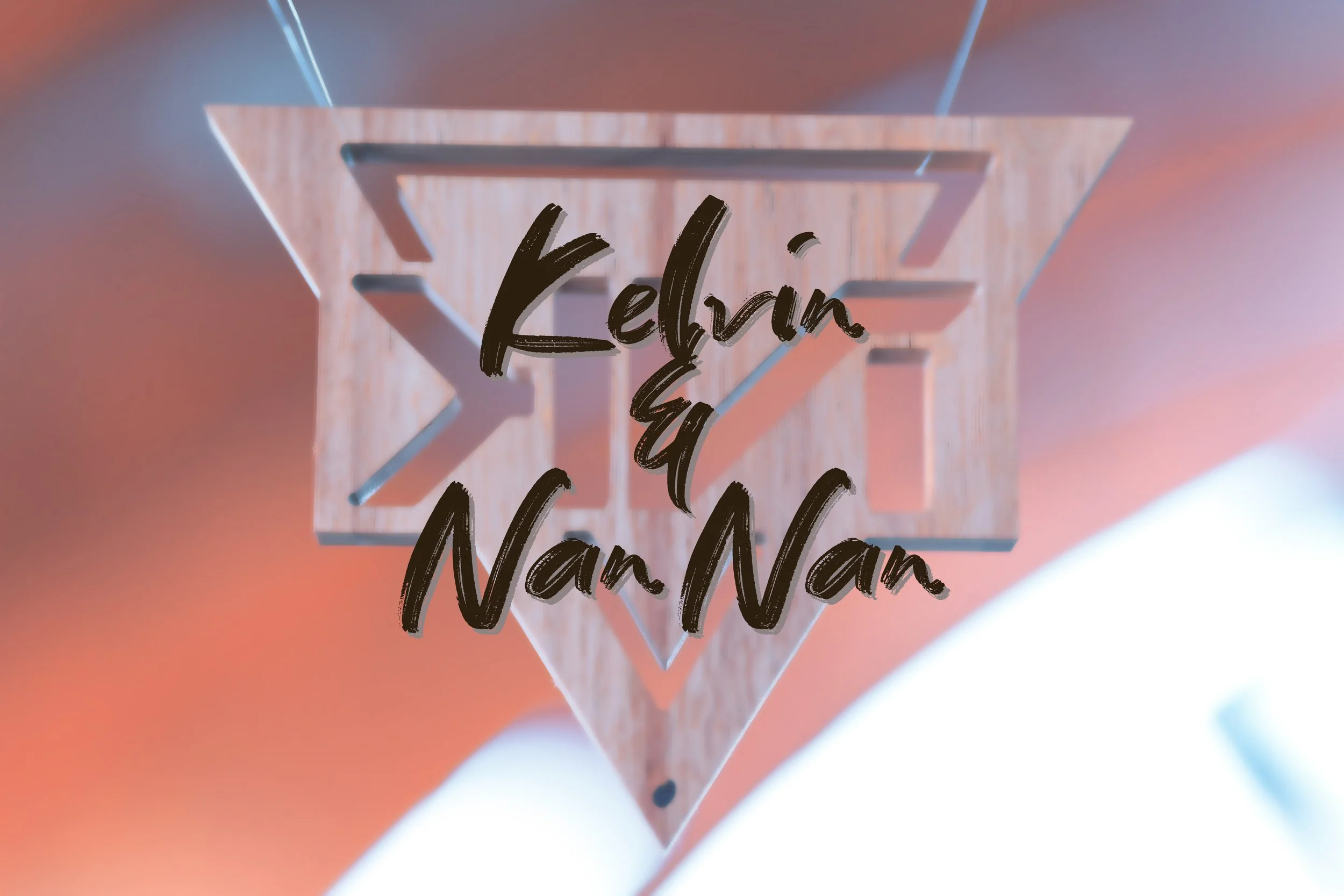Close-up of a wooden hanging ornament with the words 'Kelvin and Nan Nan' written on it.