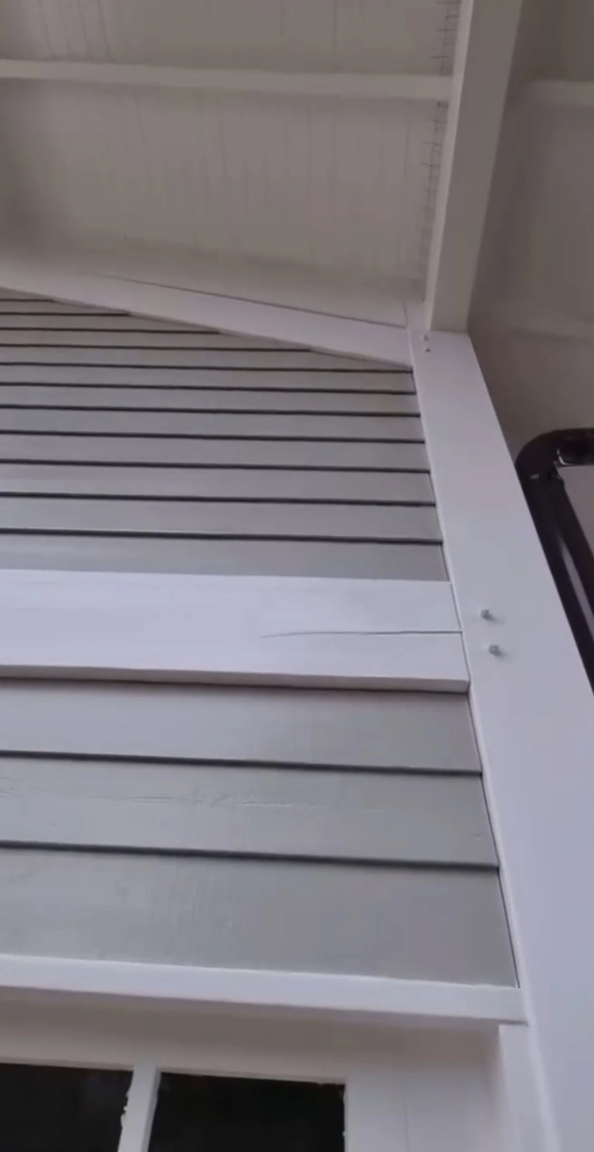 Une image montrant deux étagères blanches et une vitre avec des rayures, vue de dessous.