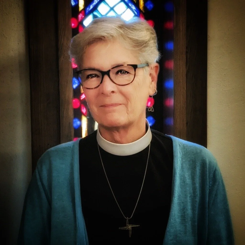 Deacon Rev. Melissa Wafer-Cross in front of a stained glass window.