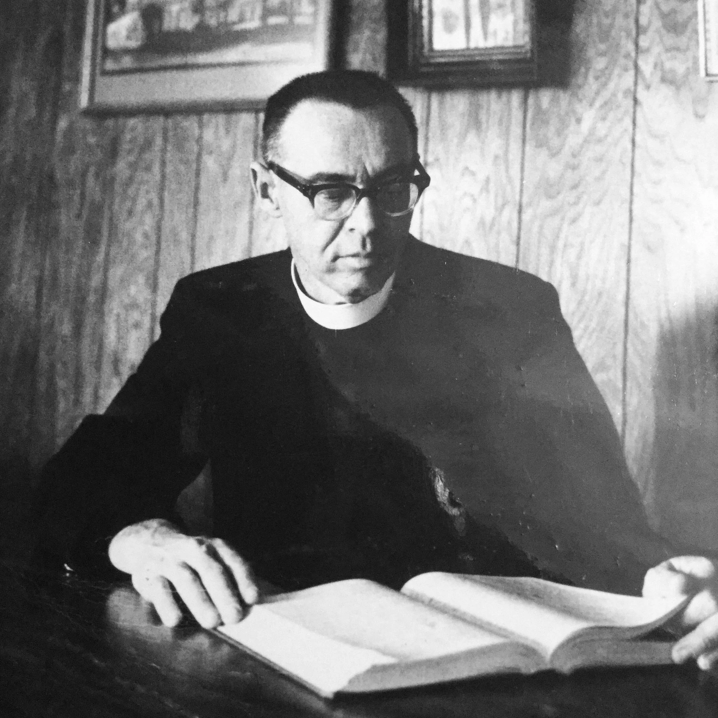 The Rev. Tom Miller reading at a desk, vicar of St. Christopher's from 1956–1968.