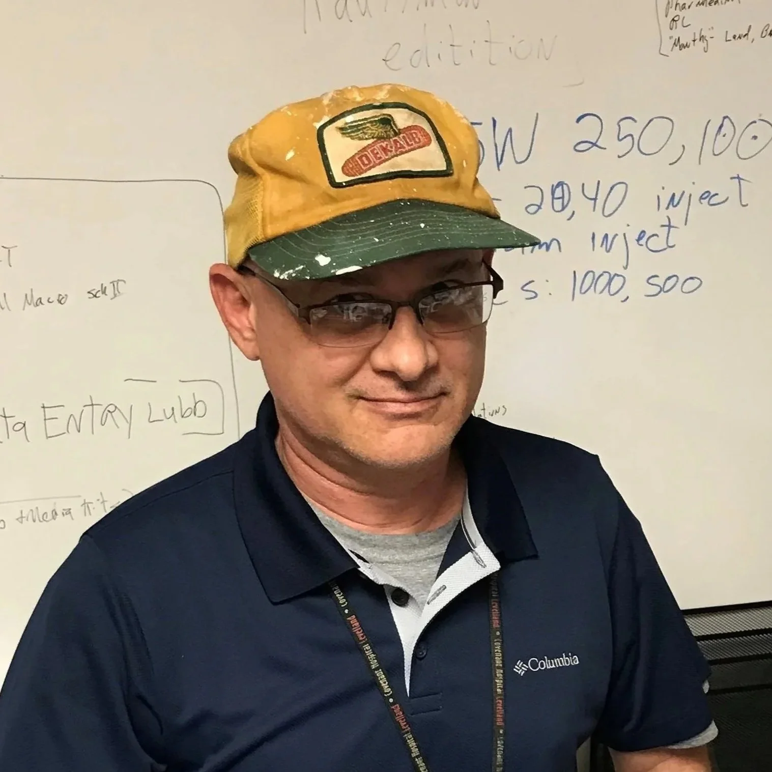 Marty smiles slightly in front of a whiteboard. 