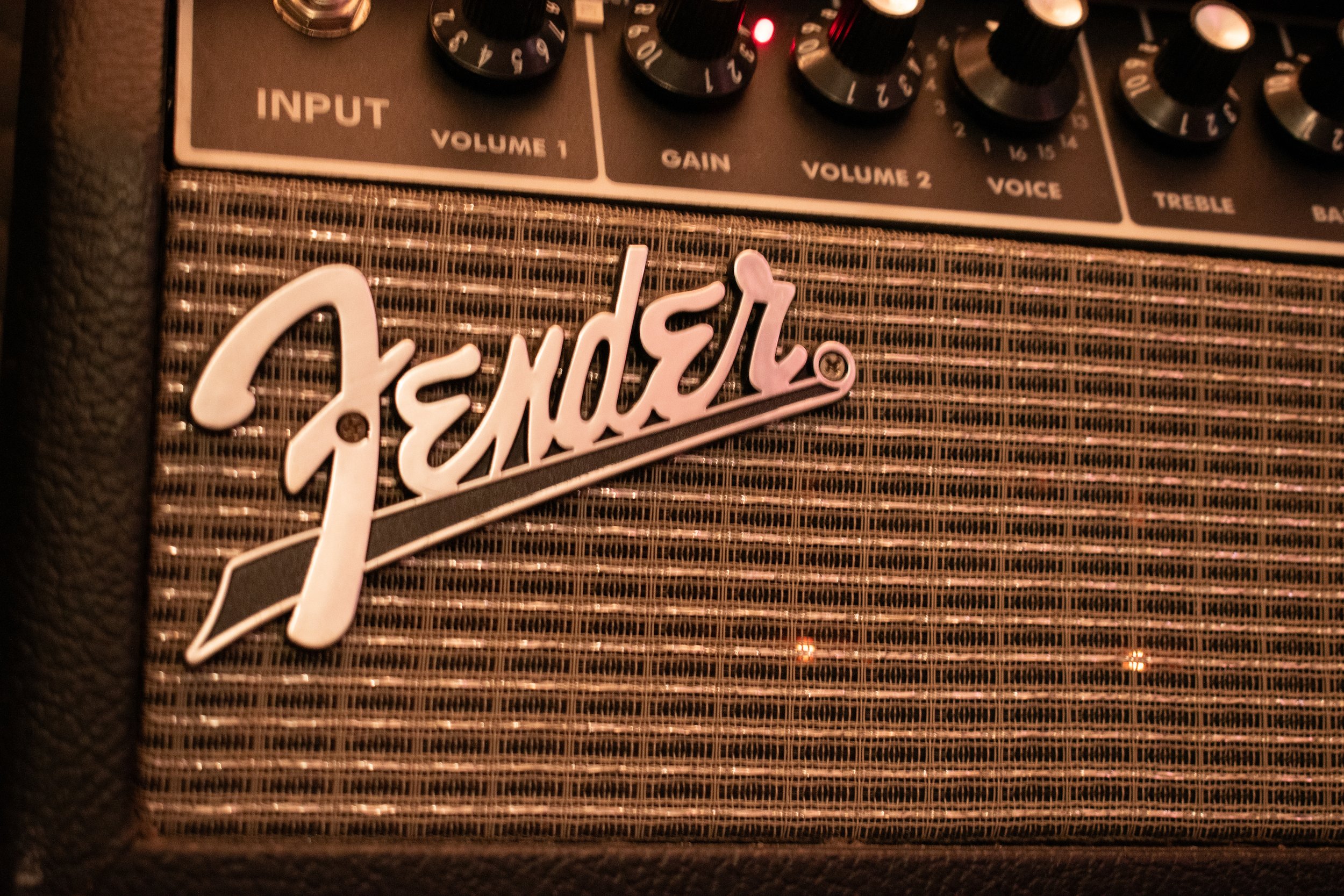 Close-up of a Fender guitar amplifier with the Fender logo on the front grille.
