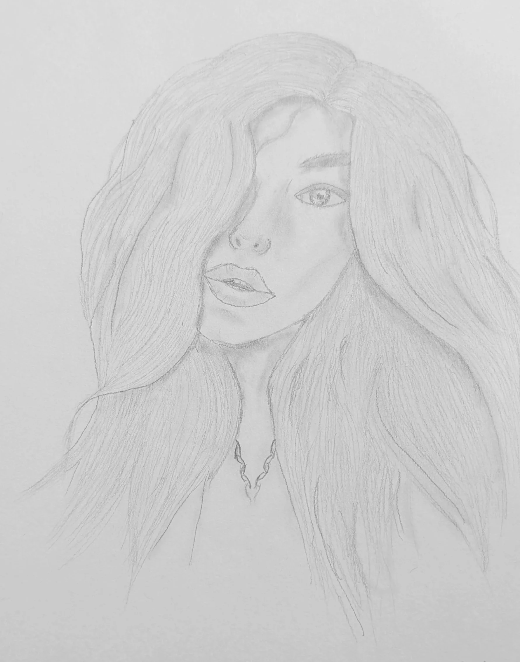 Pencil sketch of a woman with long, flowing hair covering part of her face, one eye visible, full lips, and wearing a necklace.