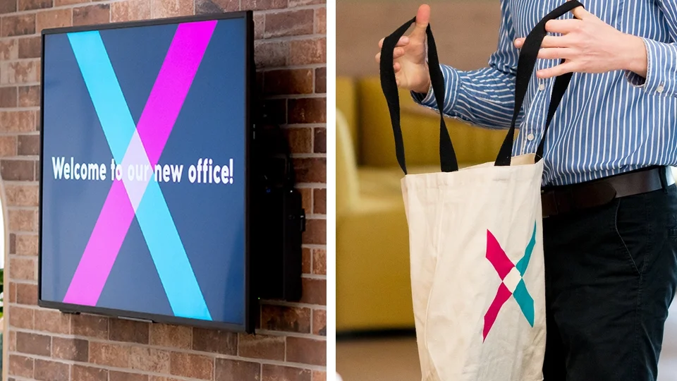 Left side: a digital screen on a brick wall displaying a colorful X logo with the text "Welcome to our new office!". Right side: a person wearing a blue striped shirt holding a white tote bag with the same X logo.
