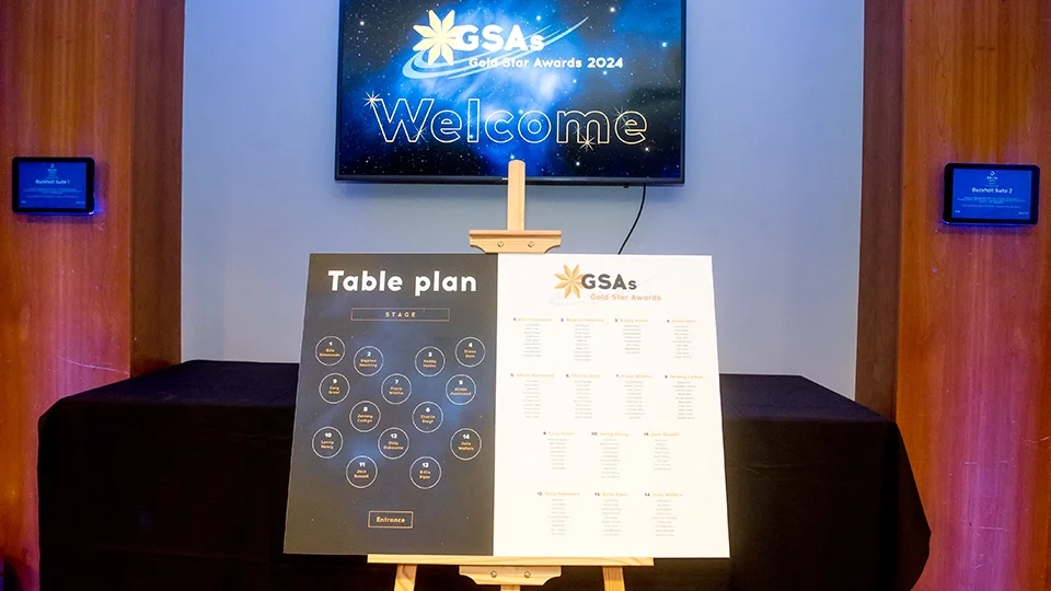 A minimalist and functional table plan design displayed on an easel. The layout uses a sophisticated dark-to-light split design, with a geometric seating map on the left and a clean, legible typographic list of guests on the right.