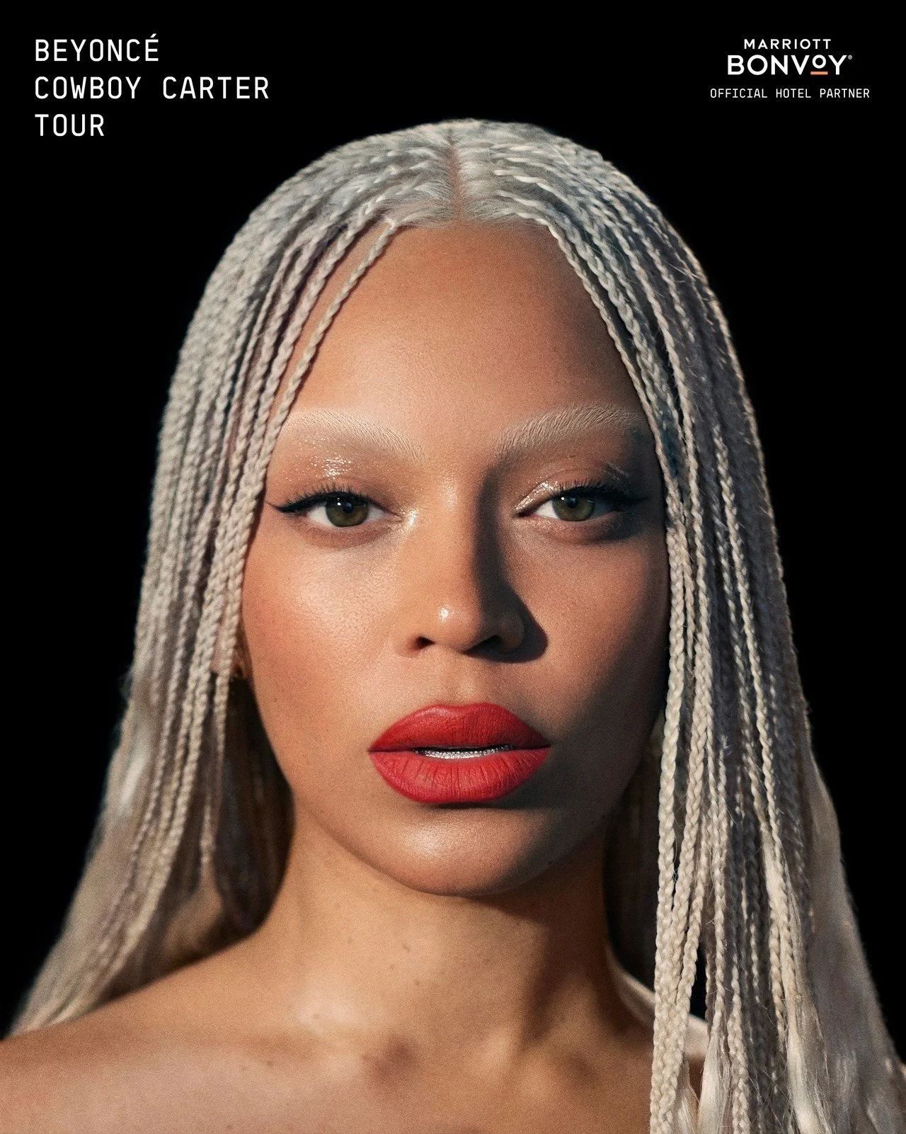 Photo d'une femme avec des cheveux blonds tressés, maquillage brillant et lèvres rouges, sur un fond noir.