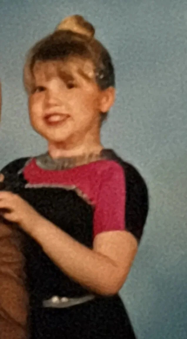 A young girl in a 90's dance outfit