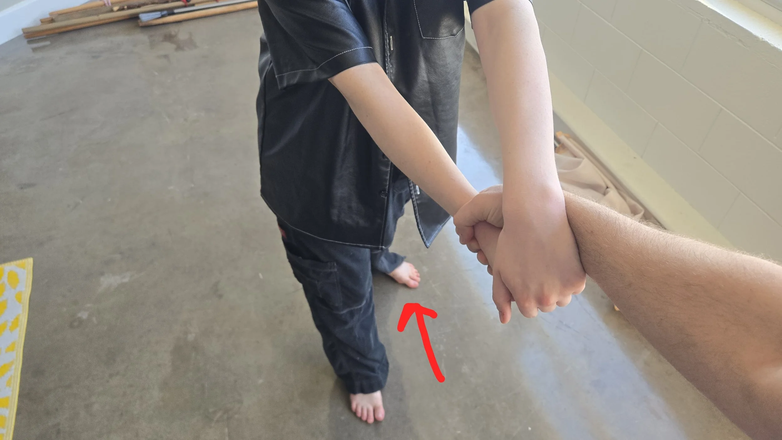 MY foot that is opposite the grabbed wrist has now stepped slightly back. Arrow indicating the straight-back movement.