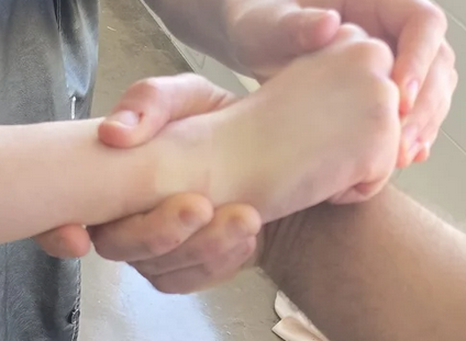 A closeup of the image where I am turning my hips. It shows the mans hand again. The man's wrist is bent in an awkward way. His thumb is barely hanhing onto my hand. There are faint lines on my wrist from where he was tightly gripping the skin.