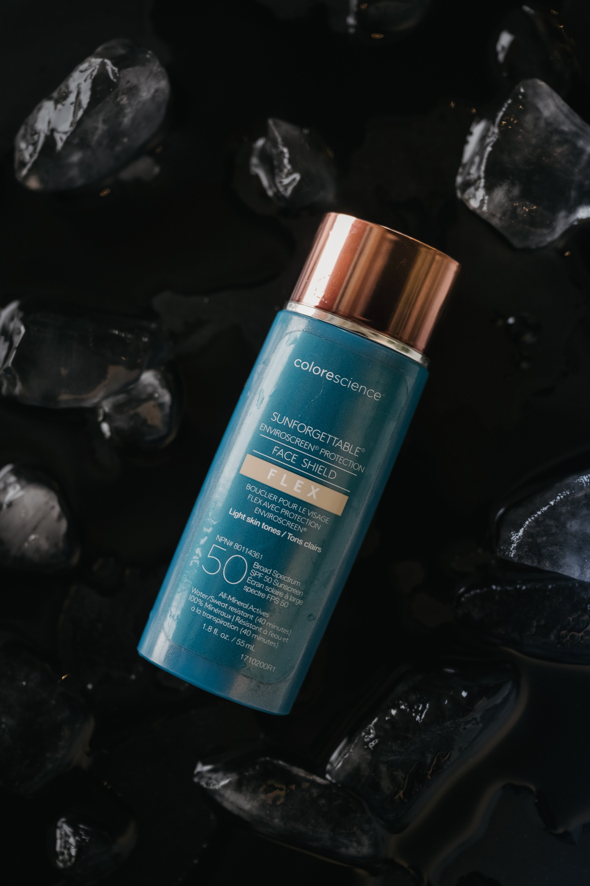 Colour Science sunscreen product, laid on a black background, with pieces of ice scattered around
