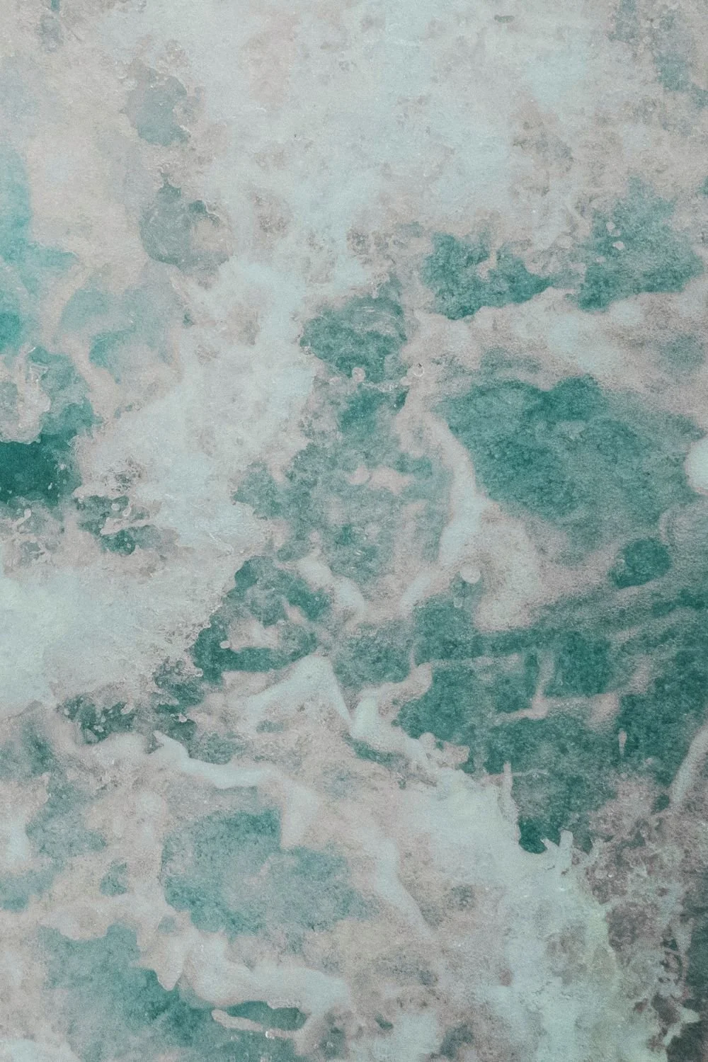 Abstract image of swirling blue, green, and white watercolor patterns.
