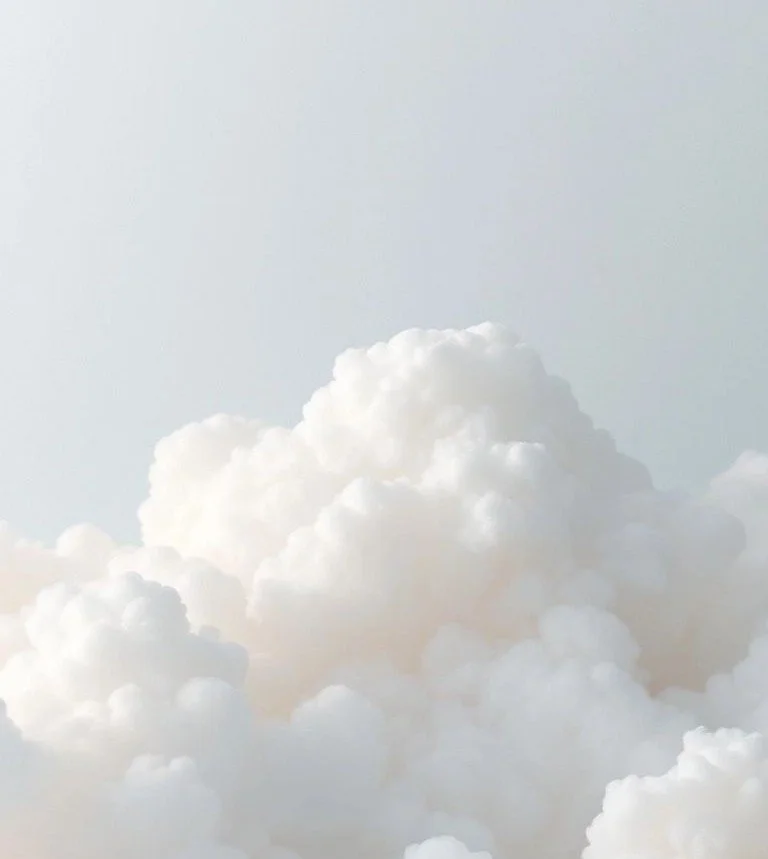A sky filled with white, fluffy clouds against a light blue background.