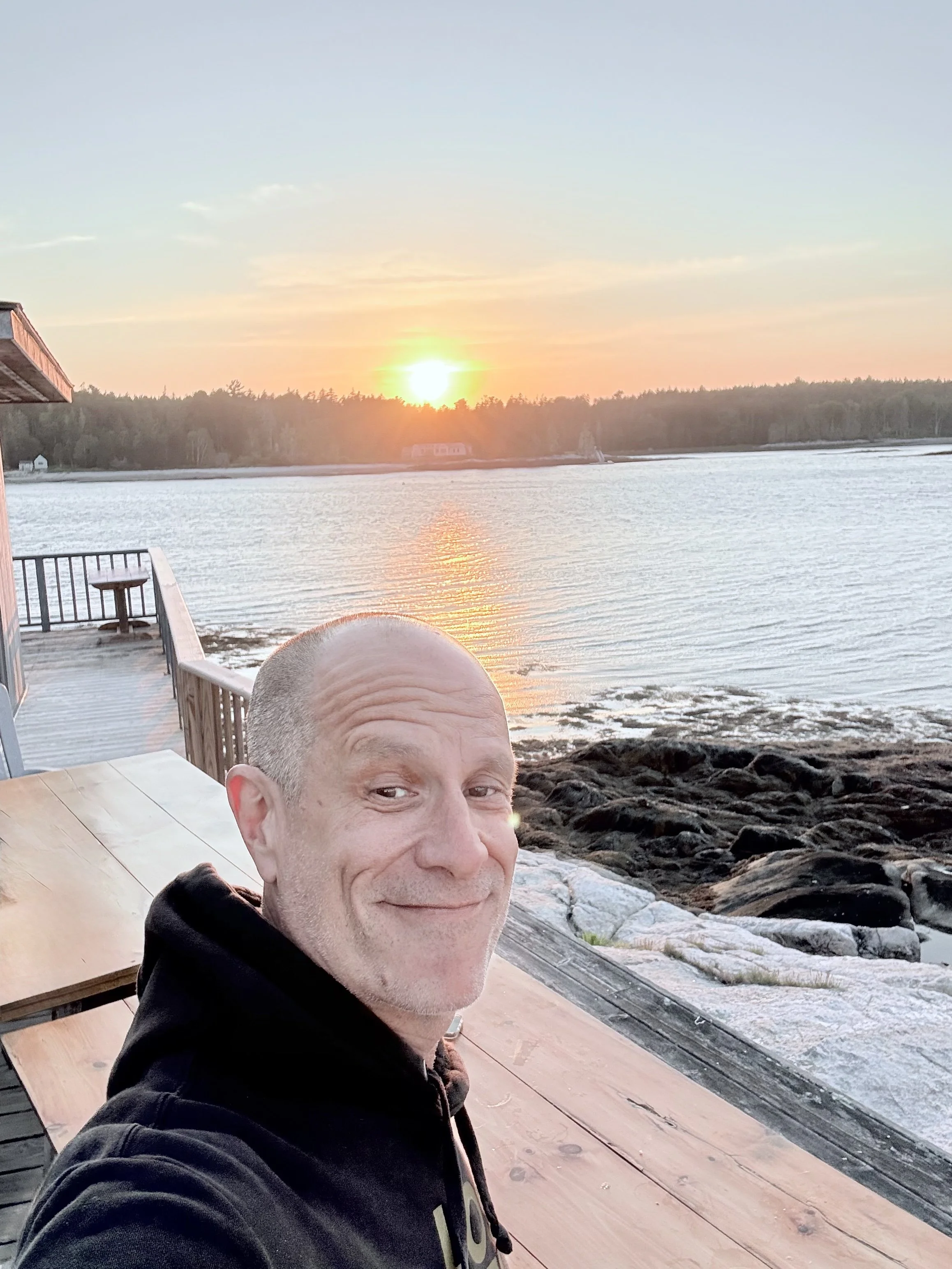 J Scavo, founder of Concierge Artist Services, smiling outdoors at sunset.