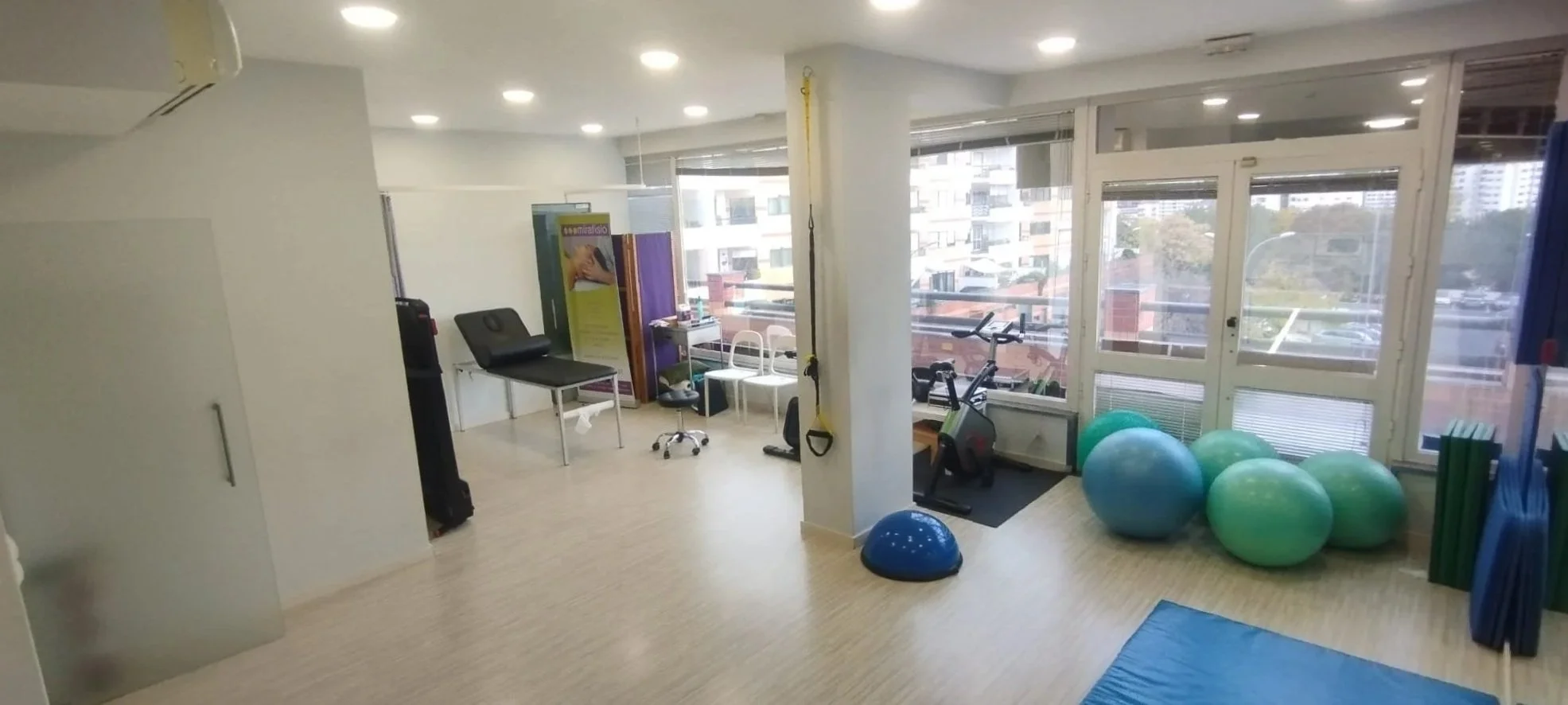 Salle de physiothérapie ou salle de gym avec équipement d'exercice, ballon de stabilité, instruments de therapy et espace pour les activités physiques.