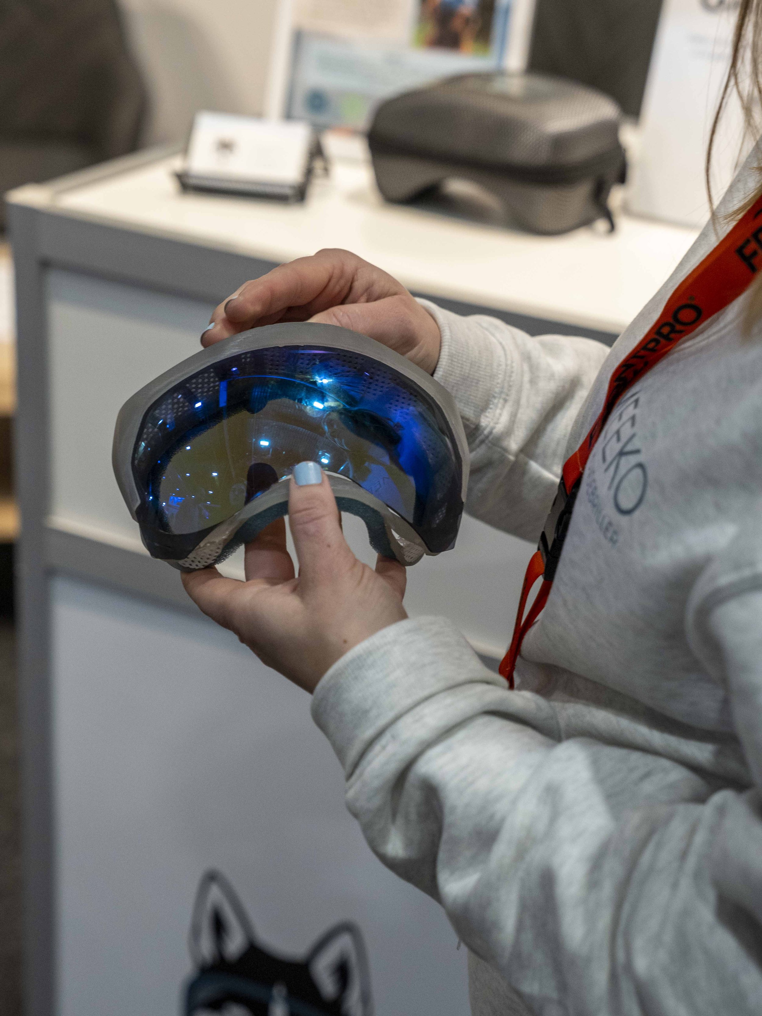 Person holding the Meeko prototype dog goggles with blue lenses at Oslo Dog Show.