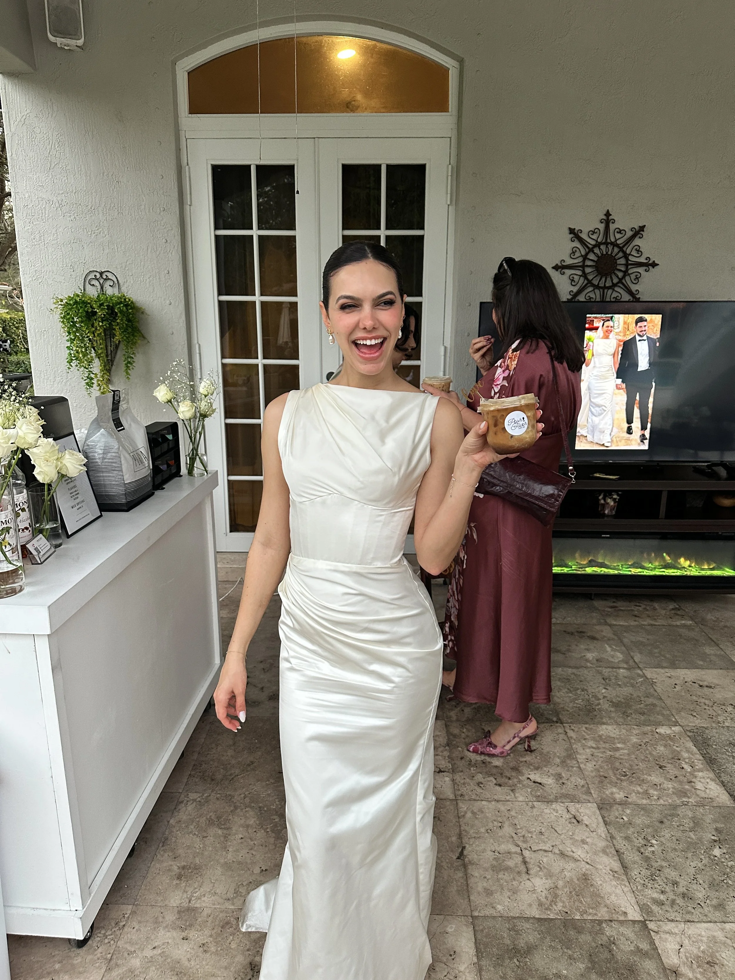 Bride holding an iced coffee from a mobile coffee bar at a Miami wedding reception