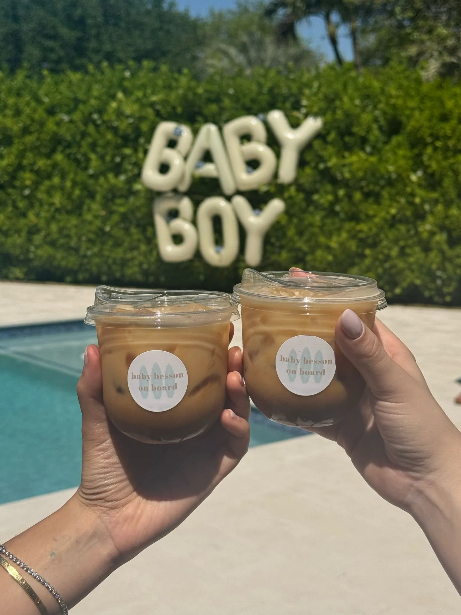 Custom iced lattes from a Miami coffee cart at a baby shower with personalized “baby on board” stickers