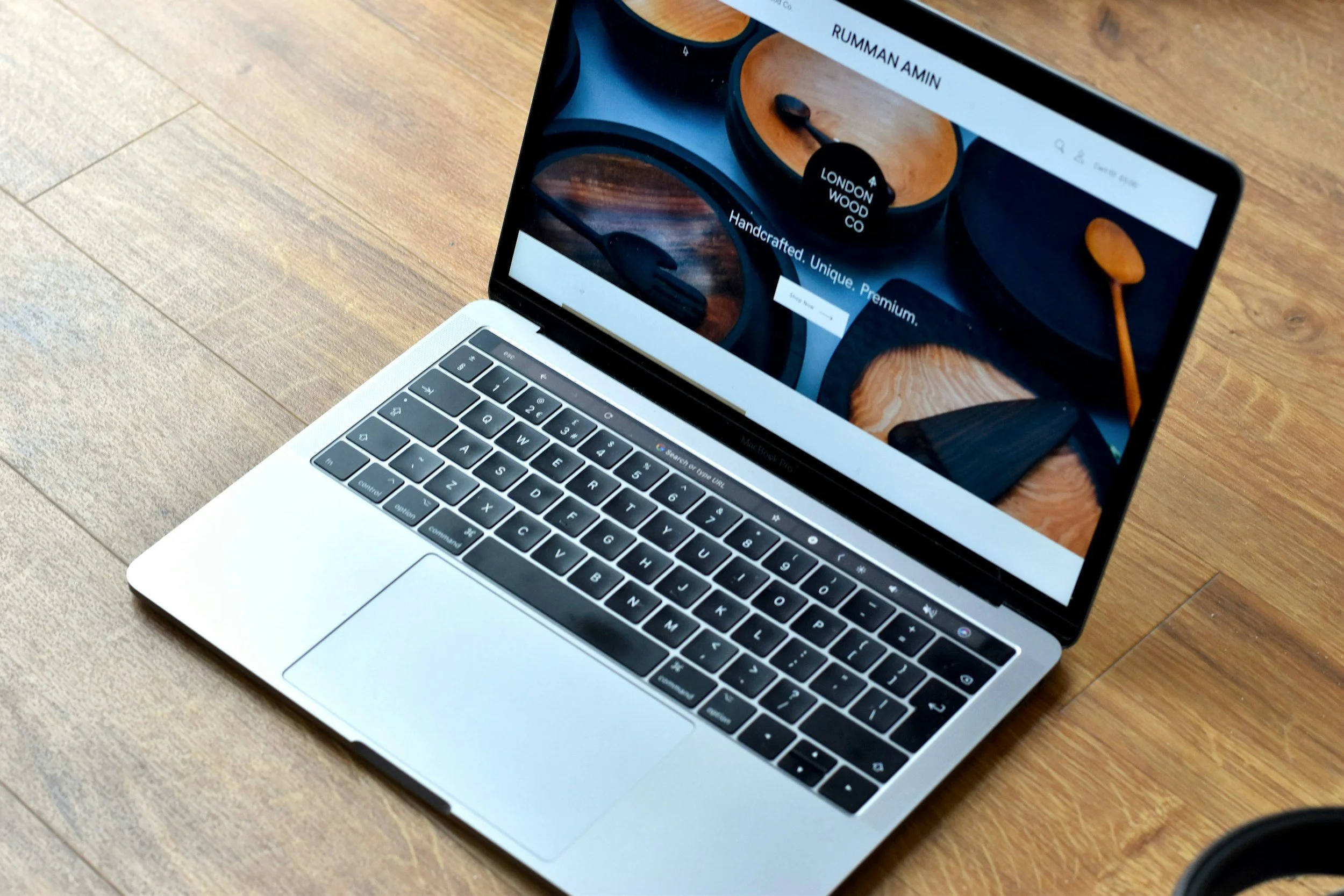 A laptop open on a wooden surface displaying a coffee website or cafe website