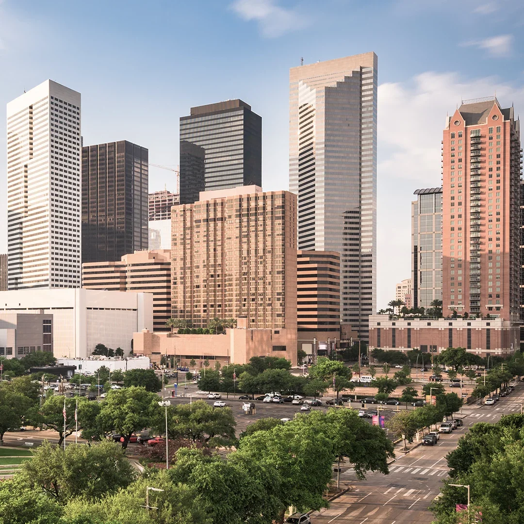 downtown-buildings-with-traffic-and-greenery-houston-hero.webp