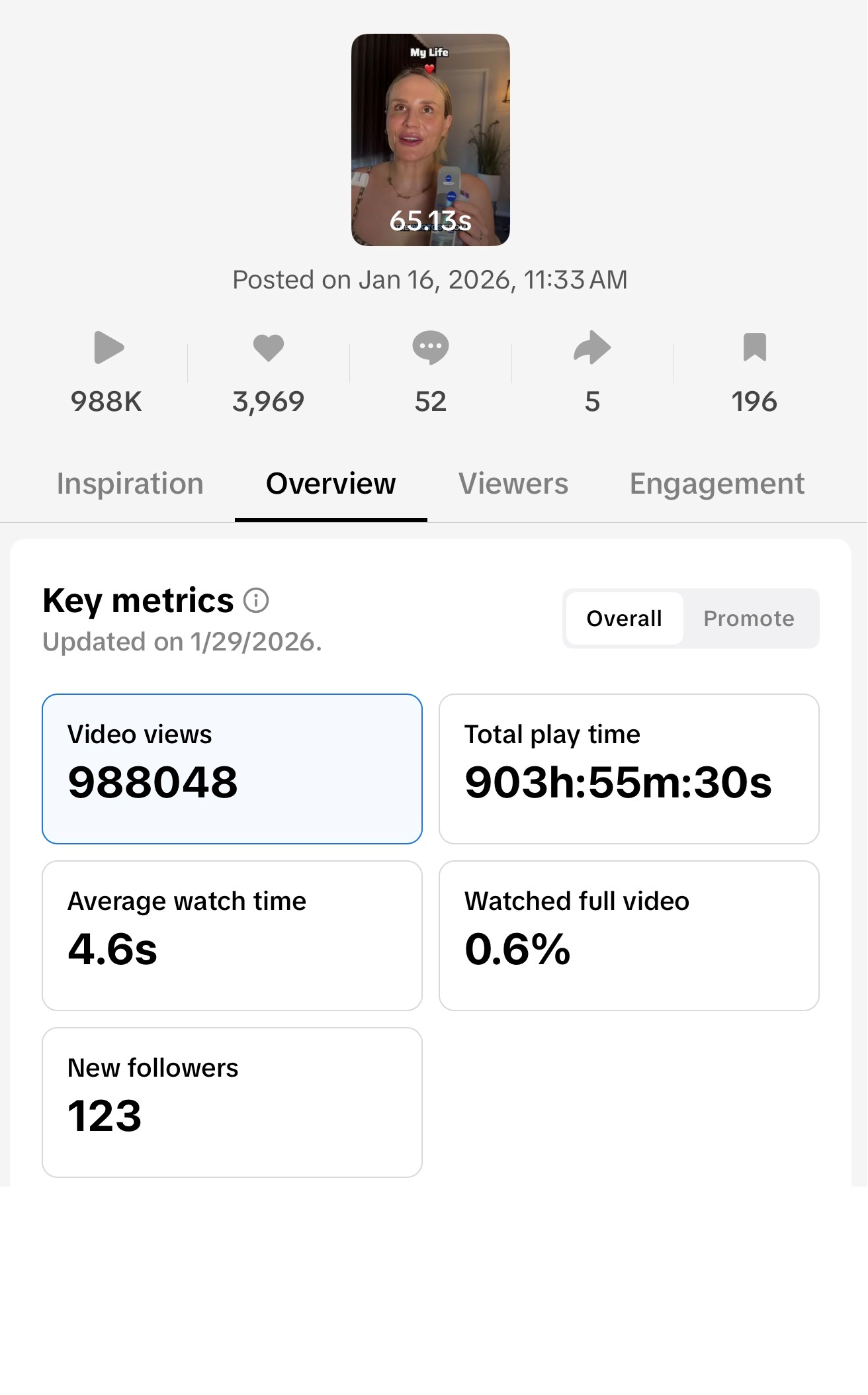 A woman holding a COVID-19 testing kit with a yellow tongue depressor, standing in a room with a dark curtain and a plant in the background. The overlay text says 'My Life' with a red heart icon and a timer of 65.13 seconds.