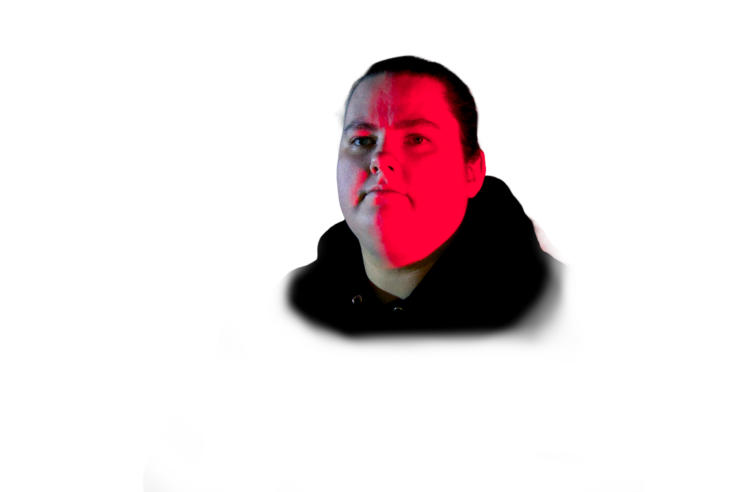 A woman with long hair and a serious expression is illuminated by red lighting from the right side, with the background completely black.